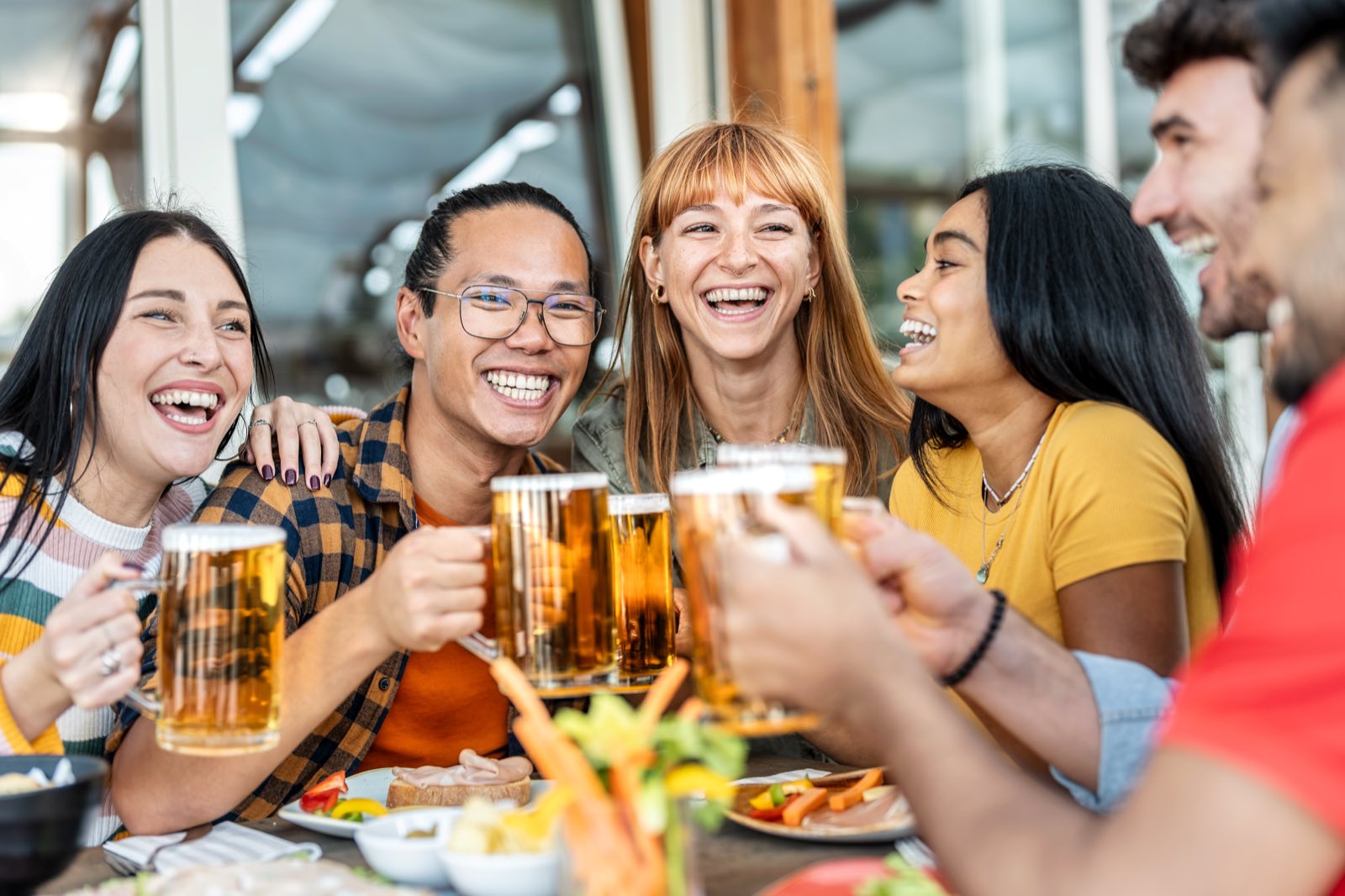 Friends sharing beers around a table during a casual event meal or team gathering